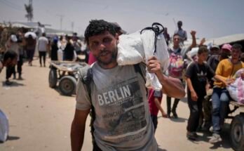 Omar al-Hobi, 43 éves, a Rafah-ból, egy zacskó ételt hordoz, amelyet a magánvállalkozó, a Gázai Humanitárius Alapítvány vezette egy disztribúciós központban, a déli Gázai övezetben, amikor június 10-én érkezett Khan Younis-i sátra.