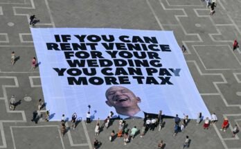 A Greenpeace Nemzetközi Környezetvédelmi Group aktivistái egy óriási zászlót mutatnak be, amely hétfőn jelenik meg Jeff Bezos fényképét a Velencei Saint-Marc Place-en.
