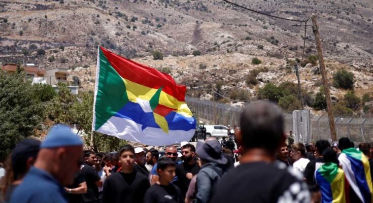 A Druze a Golan Heights faluban lévő határkerítés közelében vár, Izrael anctitált, Majdal Shams, míg a szíriai Druze, aki a napon átlépte a napot, mielőtt július 17 -én a szektáriánus véráramlás napjai után a szektáris véráramlás napjai után.